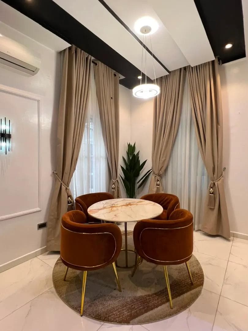Dining nook with a round marble table and four upholstered chairs