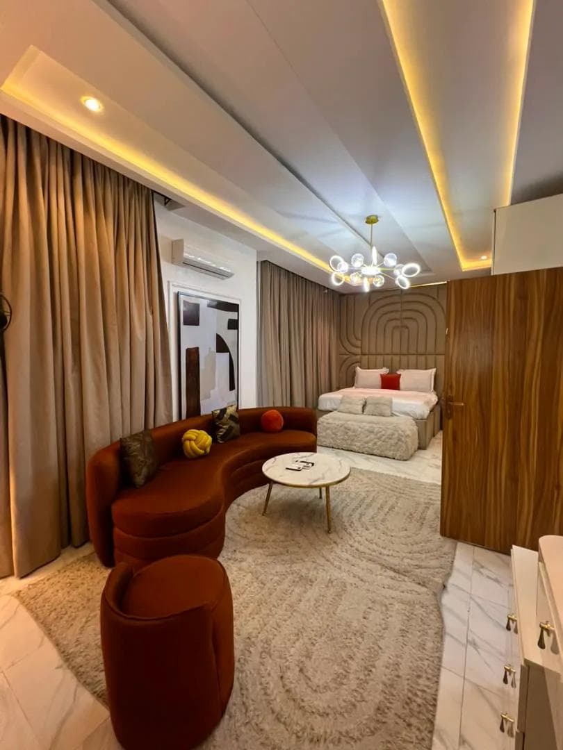 Lounge with a curved terracotta sofa beneath a chandelier